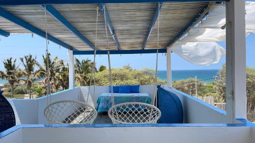 un porche con mesa, sillas y el océano en Villa Aqua Boutique Vichayito, en Vichayito