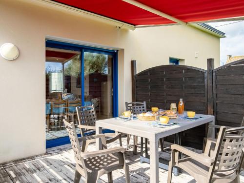 Una mesa blanca y sillas en un patio. en Holiday Home L'appel du Large by Interhome, en Kerlouan