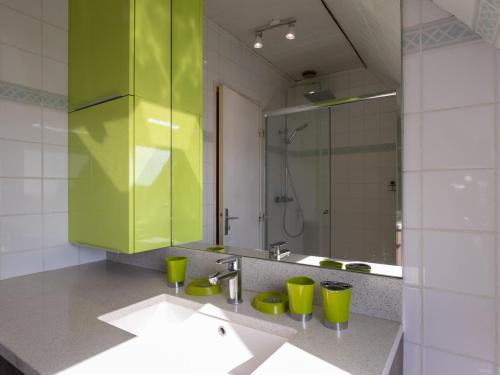 a bathroom with a green cabinet and a sink at Holiday Home Tal ar Mor by Interhome in Le Pouldu