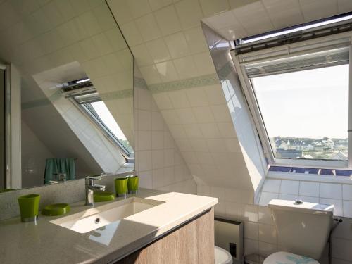 a bathroom with a sink and a toilet and a window at Holiday Home Tal ar Mor by Interhome in Le Pouldu