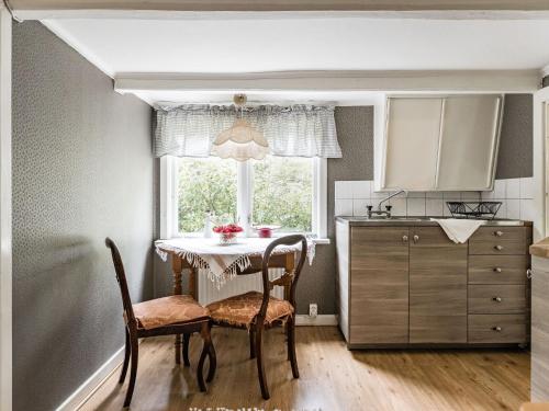 cocina con mesa, sillas y ventana en Holiday Home Angsjö Torp by Interhome, en Backaryd