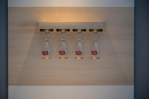 a group of wine glasses hanging on a wall at Euro Square Studios in Zagreb