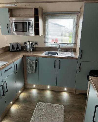 a small kitchen with a sink and a microwave at Sun sea and sand at Whitley bay in Hartley
