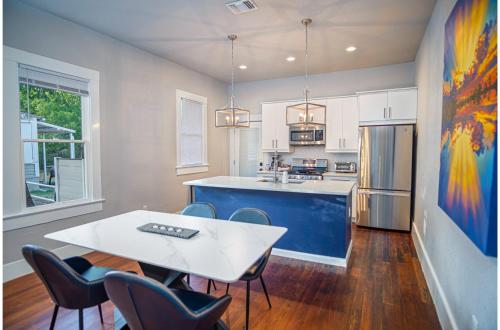 a kitchen with a white table and chairs in a room at Chic Downtown Farmhouse with Garden and BBQ Grill in San Antonio