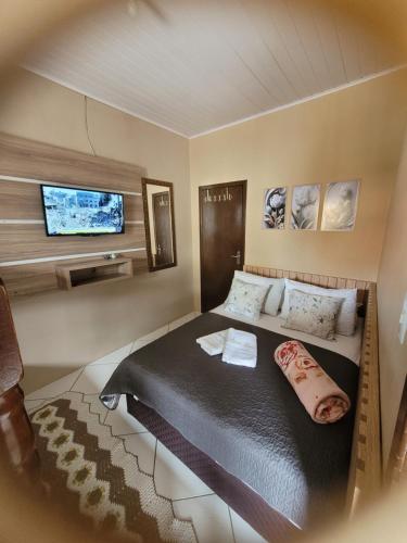 a bedroom with a bed and a flat screen tv at Apart Luis in Penha