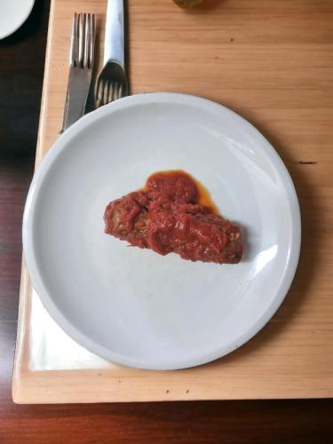 a white plate with a piece of food on a table at Agriturismo Caperroni in Pescopagano