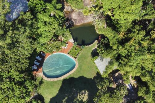 uma vista superior de uma piscina numa floresta em Casas D’Água Doce - Casa da Árvore em Ilhabela