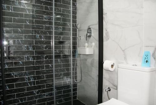 a bathroom with a shower with a black tile wall at Bungalow en Los Balcones planta baja manzana 5 numero 18 in Alicante