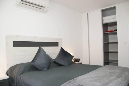 1 dormitorio con 1 cama con 2 almohadas azules en Bungalow en Los Balcones planta baja manzana 5 numero 18, en Alicante