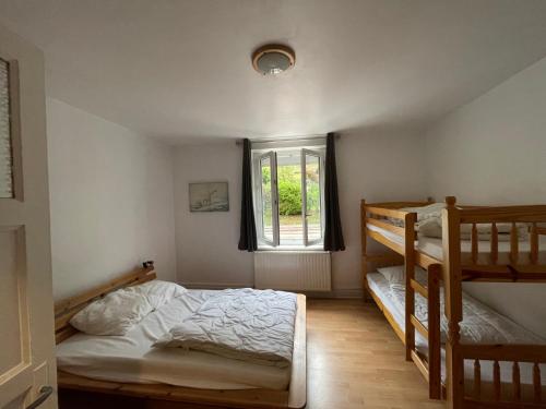 a bedroom with two bunk beds and a window at Appart La Bresse - Idéal Famille - Entre Village et Station in La Bresse
