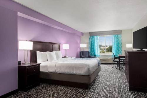 ein Hotelzimmer mit einem Bett und einer lila Wand in der Unterkunft La Quinta by Wyndham Cookeville in Cookeville