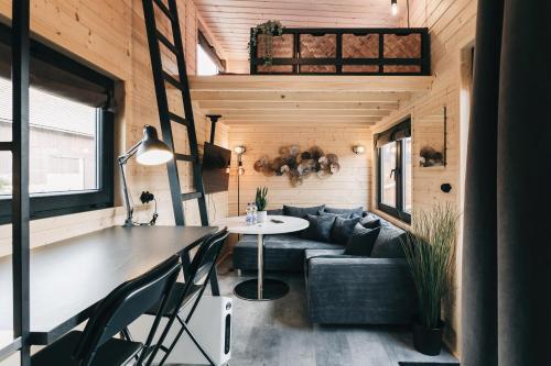 a living room of a tiny house with a table and a couch at Idyllisches Tiny House mit Sauna in Löbau