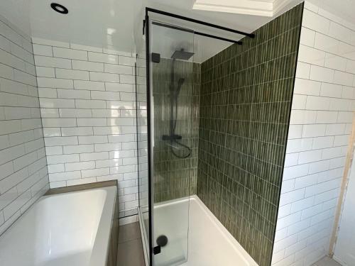 een douche met een glazen deur naast een bad bij Salt Cottage in Redcar