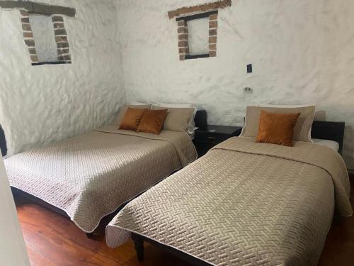 two beds sitting next to each other in a room at Hotel Colonial Centro Historico in Tunja