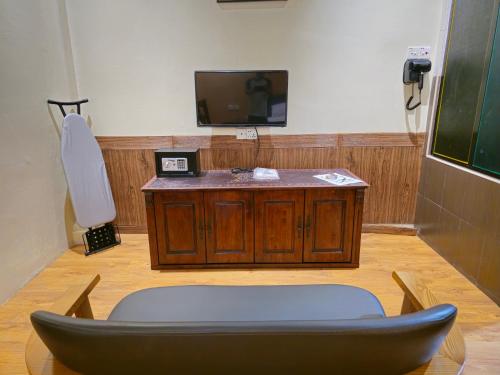 a room with a tv and a chair and a table at 乔治市世纪酒店 The Century Boutique Hotel George Town in George Town