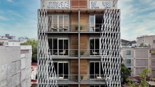 a building with a facade with white lattice at New Apartments La Condesa by VIATO in Mexico City