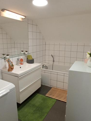 La salle de bains blanche est pourvue d'une baignoire, d'un lavabo et d'une baignoire. dans l'établissement Rare à Colmar - Appartement Champ de Mars vue sur Parc - 70m2 - 2 chambres, à Colmar
