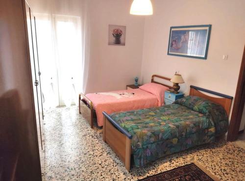 sypialnia z 2 łóżkami i łóżkiem oraz oknem w obiekcie La casetta di Angela w mieście Lanciano