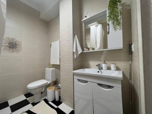 ein Badezimmer mit einem weißen Waschbecken und einem WC in der Unterkunft Просторные двухкомнатные апартаменты Терракота in Almaty
