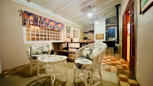 Habitación con 2 sillas, mesa y mesa. en Nena's House - Banheira de Hidromassagem-10 Pessoas, en Gramado