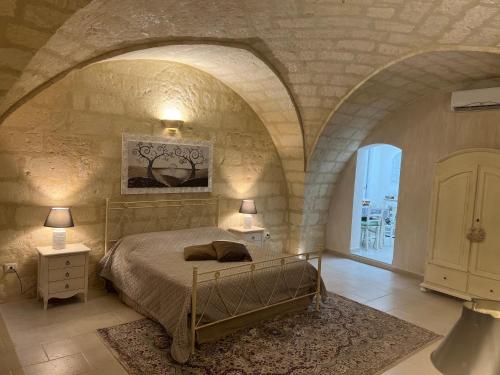 a bedroom with a bed in a stone wall at Suite Cavour Luxury Home Taranto in Taranto