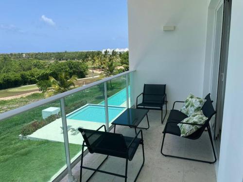 balcone con 3 sedie e piscina di Hard Rock at Cana Rock 3 by Unwind Properties a Punta Cana