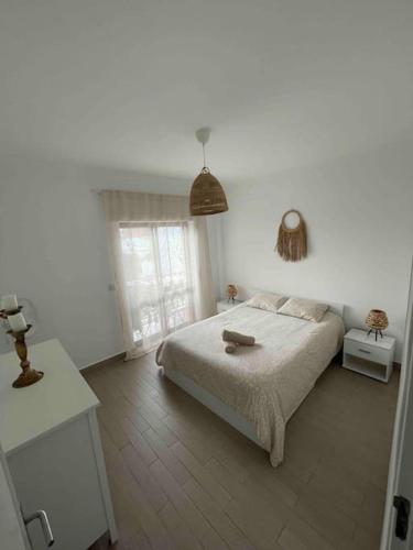 ein weißes Schlafzimmer mit einem Bett und einem Fenster in der Unterkunft Casa Carvalho in Quinta do Conde