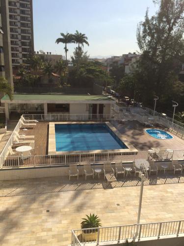 a large swimming pool with chairs and a building at Tropical Barra Hotel in Rio de Janeiro