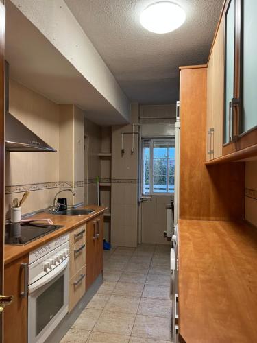 uma cozinha com um lavatório e um fogão forno superior em Apartamento Abrante em Madri