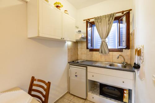a small kitchen with a sink and a window at Katerina Studios Mparou in Apollonia