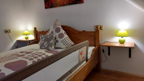 a bedroom with a bed with two lamps and two tables at Titi Boutique Apartmanok in Bükfürdő