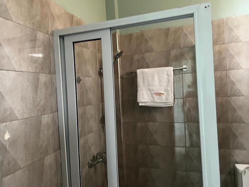 una ducha con una toalla blanca en un toallero en Jackie Grand Hotel, en Cape Coast
