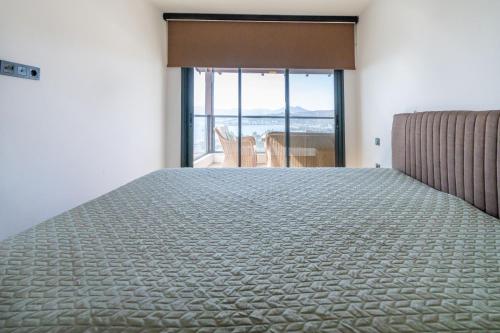 a bedroom with a large bed with a view of the ocean at Villa Bitez in Bodrum City