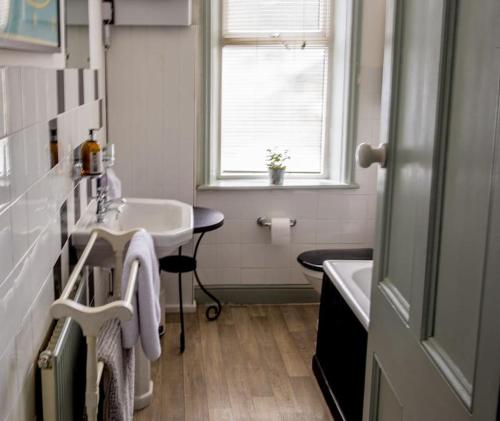 a bathroom with a sink and a tub and a window at Heart of Hebden in Hebden Bridge