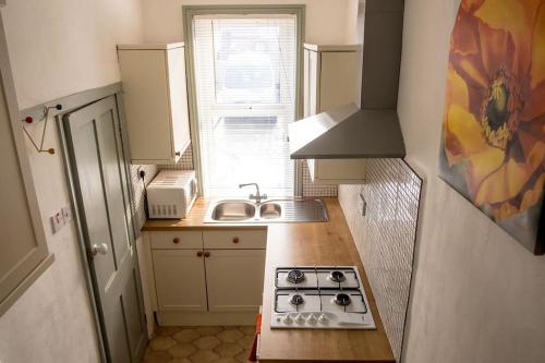 a small kitchen with a stove and a sink at Heart of Hebden in Hebden Bridge