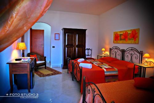a bedroom with two beds and a table and a chair at B&B L'Orizzonte in Castro di Lecce