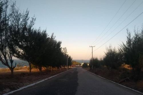 an empty road with trees on the side of the road at Paraiso frente ao mar, réplica de uma vila grega! in Aracati
