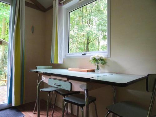 a room with a desk with stools and a window at La Roulotte à 10min de Disneyland Paris - Cabane & Cabanon in Chalifert