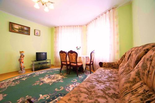 ein Wohnzimmer mit einem Sofa und einem Tisch mit Stühlen in der Unterkunft Новобудова 2 кімнати Вернадського 8 in Lwiw