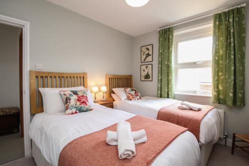 une chambre avec deux lits avec des serviettes dessus dans l'établissement The Corner House, à Weymouth