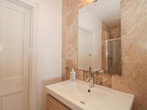 W łazience znajduje się umywalka i lustro. w obiekcie 49 Esplanade w mieście Burnham-on-Sea