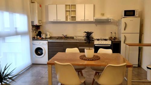 cocina con mesa de madera y electrodomésticos blancos en PRISMA CUARENTA en Villa Carlos Paz
