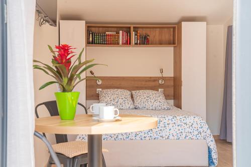 Un dormitorio con una cama y una mesa con una planta en chez pascal et olivier, en Saint-Chamas