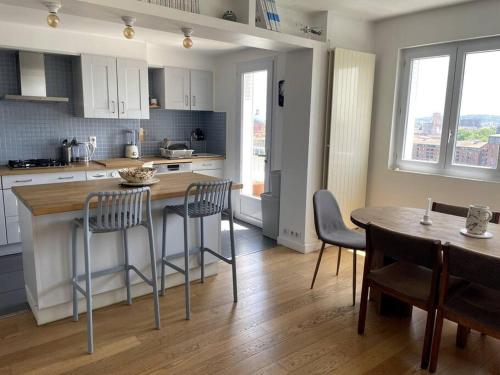 une cuisine avec une table et des chaises ainsi qu'une salle à manger dans l'établissement La garonnette, vue toulousaine, à Toulouse