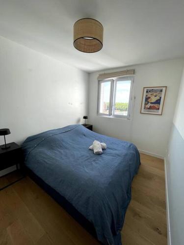 une chambre avec un lit avec un animal en peluche dessus dans l'établissement La garonnette, vue toulousaine, à Toulouse