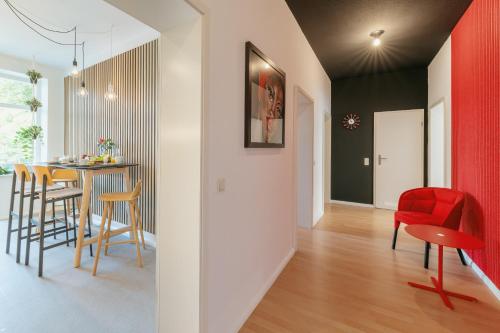 eine Küche und ein Esszimmer mit roten Stühlen und einem Tisch in der Unterkunft Premium Quartier "Karl" auf dem Kaßberg mit eigenem Stellplatz in Chemnitz