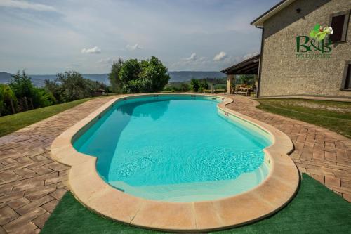 a swimming pool with a brick walkway around it at B&B dell'Aviatore in San Liberato