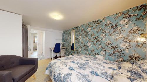 1 dormitorio con 1 cama y 1 silla en BLUE ROOM Chez Steve, en Chennevières-sur-Marne