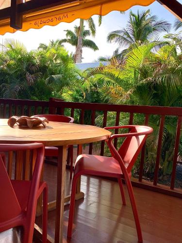a table and chairs on a balcony with a view of palm trees at Domaine Saint-François in Saint-François