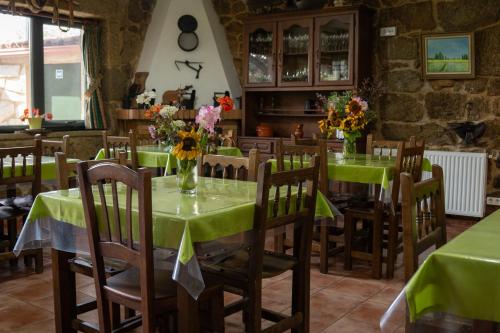 uma sala de jantar com mesas verdes e cadeiras com flores em Casa A Chairiña y A Revolta em Arnoia